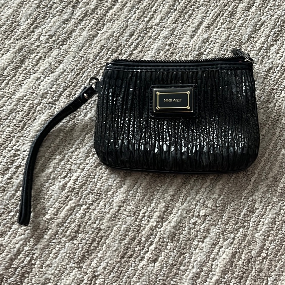Nine West wristlet with patent handle.